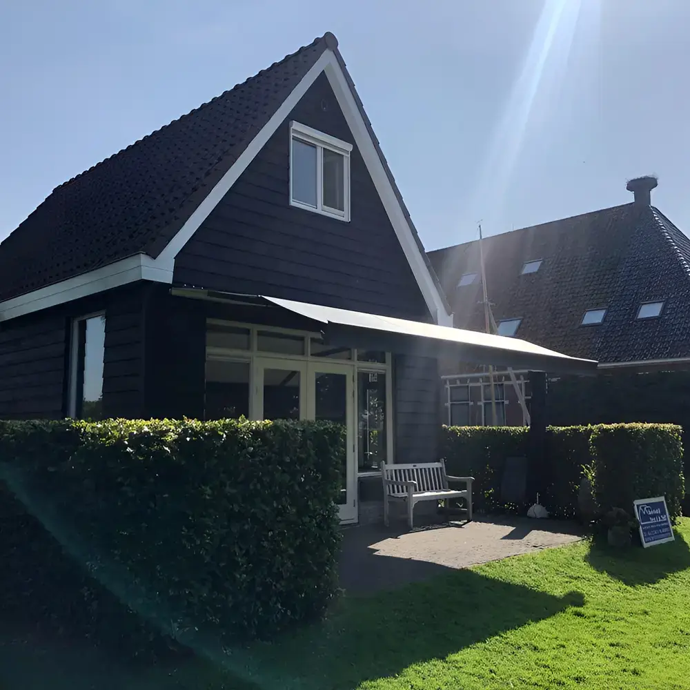Zon en regenscherm aan landelijk huis in Broek geplaatst door Veldman Zonwering