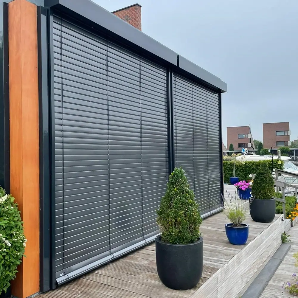 Buitenjaloezieen volledig gesloten op een terras met houten gevel en bloempotten